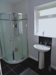 a bathroom with a glass shower and a sink at Cushendall Cottage, Moneyvart in Cushendall