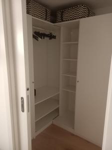 a closet with white shelves and a ceiling at Cjase Vecje in Sùtrio