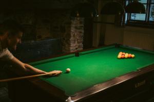 a woman playing a game of pool on a pool table at The Heathfield Inn in Honiton