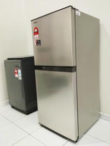 a stainless steel refrigerator next to a trash can at Mukmin 2 Stay in Malacca +8 photos