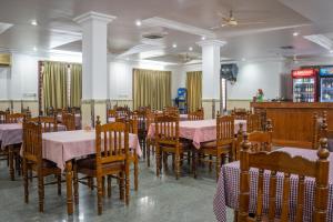 a dining room with tables and chairs with pink tablecloths at Marine Palace Beach Hotel in Kovalam