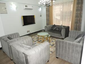 a living room with two couches and a table at MJ Hosting in Dar es Salaam