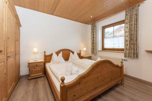 a bedroom with a large wooden bed and a window at Appartements Coburg by Schladming-Appartements in Schladming