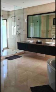 un bagno con due lavandini e un grande specchio di Villa Mazagan de luxe 6 chambres face mer 1000m2 a El Jadida