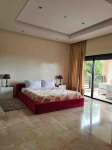 una camera con un grande letto e una grande finestra di Villa Mazagan de luxe 6 chambres face mer 1000m2 a El Jadida
