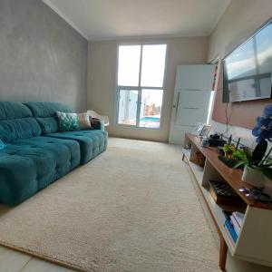 Vivenda Bela Vista في بويتوفا: غرفة معيشة مع أريكة زرقاء في غرفة