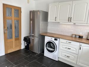 eine Küche mit einem Kühlschrank und einer Waschmaschine in der Unterkunft Impeccable 3-Bed House in Nottingham in Nottingham