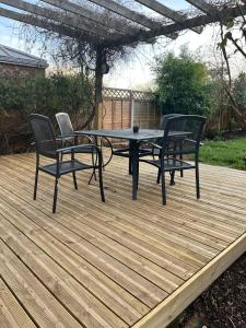 a picnic table and chairs on a wooden deck at Impeccable 3-Bed House in Nottingham in Nottingham