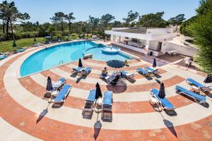 une image d'une piscine avec des chaises et des parasols dans l'établissement Grey Heron Apartment, à Quinta do Lago