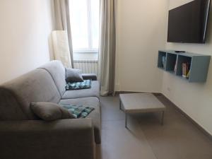 a living room with a couch and a tv at Re Federico Apartment in Palermo