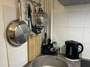 巴黎的住宿－Cozy studio in Paris 15eme，厨房水槽上挂着锅碗瓢盆