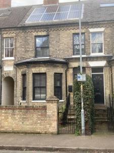 a brick house with solar panels on the front of it at Self-contained, private entrance, near city centre in Norwich