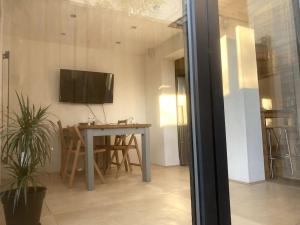 a room with a table and a television on a wall at Self-contained, private entrance, near city centre in Norwich