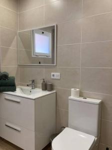 ein Badezimmer mit einem WC, einem Waschbecken und einem Spiegel in der Unterkunft Cosy ocean view studio 2 in San Marcos