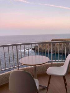einen Tisch und Stühle auf einem Balkon mit Meerblick in der Unterkunft Cosy ocean view studio 2 in San Marcos