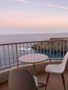 a table and chairs on a balcony with the ocean at Cosy ocean view studio 2 in San Marcos