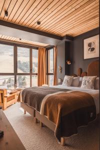 sypialnia z dużym łóżkiem i dużym oknem w obiekcie La Voie Lactée w mieście La Mongie