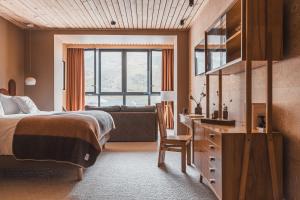 a bedroom with a bed and a desk and a couch at La Voie Lactée in La Mongie