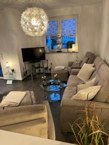sala de estar con sofá y lámpara de araña en Ferienwohnung Ida, en Polch