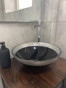 a bathroom with a black sink on a wooden table at Newly refurbished apartment, near station & river in London