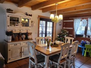 a kitchen with a table and chairs and a christmas tree at Zagroda Krasna in Polańczyk