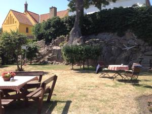 a group of picnic tables and chairs in a yard at Hotel Klostergaarden in Allinge