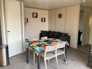Habitación con mesa, sillas y sofá en COTTAGE 4/5 pers en Jullouville-les-Pins