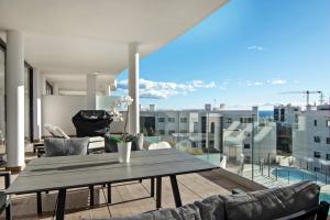 einen Esstisch auf einem Balkon mit Stadtblick in der Unterkunft Mara's Apartments Higueron West - Modern Large Apartment - 50 metres of terrace with sea views and afternoon sun !!!! in Fuengirola