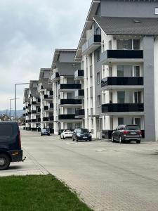 a parking lot with cars parked in front of apartment complexes at Apartament Evelyne Râșnov in Râşnov