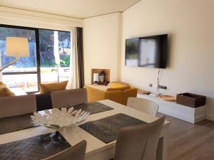 a living room with a table and a dining room at Grey Heron Apartment in Quinta do Lago