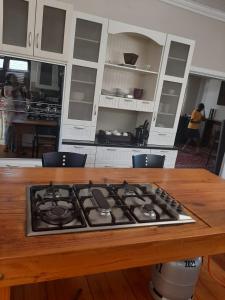 uma cozinha com uma placa de fogão numa mesa de madeira em Fun-filled, cosy family home em Gqeberha