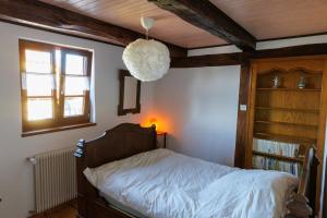 sypialnia z łóżkiem z lampką i półką na książki w obiekcie Chez Franz Alois w mieście Ueberstrass