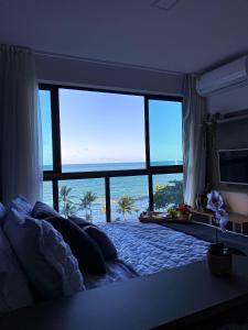 um quarto com uma cama e vista para o oceano em Flats de Luxo by BnbFlex - Costa Vicentina no Recife