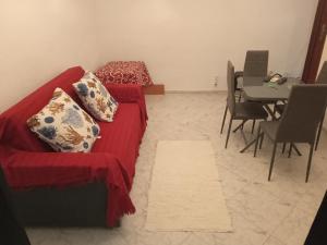Una sala de estar con un sofá rojo y una mesa. en Torremolinos Delia2, en Torremolinos