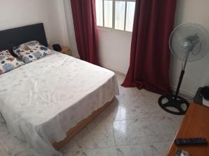 Un dormitorio con una cama con ventilador y una ventana. en Torremolinos Delia2, en Torremolinos