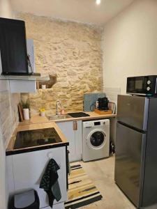 uma pequena cozinha com um fogão e um frigorífico em Charmant P3 en centre ville em Nîmes