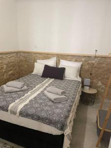 uma cama grande com almofadas num quarto em Charmant P3 en centre ville em Nîmes