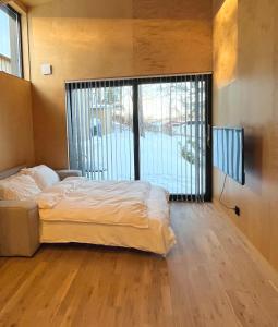 a bedroom with a bed and a large window at Peaceful studio loft, Stockholm in Stockholm