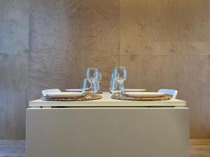 a white table with two plates and glasses on it at Peaceful studio loft, Stockholm in Stockholm