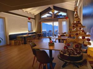 una habitación con un árbol de Navidad, mesas y sillas en Le Rocce Val di Non - Quality Room & Breakfast, en Tassullo