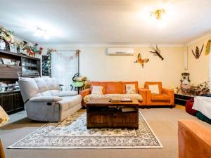 sala de estar con sofá y mesa en Homestay - Large Private Room With A King Size Bed - SHARED Bathroom FREE Kitchen Essentials Milk, Bread, Tea, Coffee and Cereal WIFI HDTV FREE Laundry Service Meal and Transportation services available on request, en Bidwill