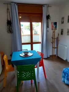 una mesa azul y sillas en una habitación con ventana en La Dolce Vita - Apartment with shared pool and large terrace, en Lido delle Nazioni