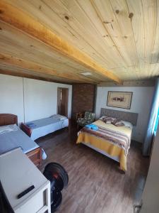 um quarto com 2 camas e um tecto de madeira em Refúgio da Mata Atlântica Sobrado Centenário em Torres
