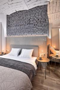 - une chambre avec un grand lit et un mur en briques dans l'établissement Długa 18 Apartament Premium z wanną i sauną, à Poznań