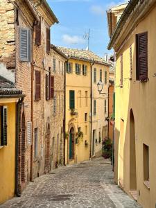 Une ruelle dans une vieille ville avec des bâtiments dans l'établissement L'Antica Colombaia; B&B room with private terrace, à Ostra