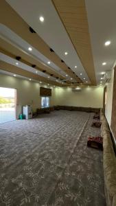 a large room with a carpeted floor and a large window at مزرعة القمة in Mogayra