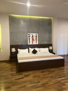 um quarto com uma cama com um quadro na parede em Thalangama Lakeview Lodge em Battaramulla