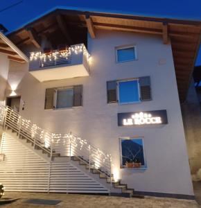 un edificio blanco con escaleras y luces en Le Rocce Val di Non, en Tassullo