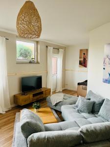 ein Wohnzimmer mit 2 Sofas und einem TV in der Unterkunft Ferienwohnungen Maedchen in Wunstorf