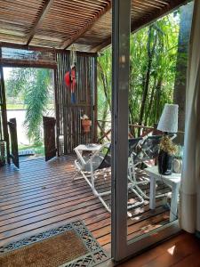 a porch with chairs and a table and a desk at Itaca delta cabañas in Tigre